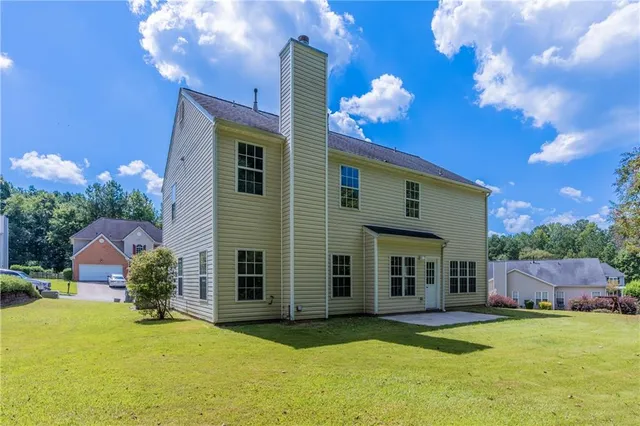 a view of a house with swimming pool and a yard
