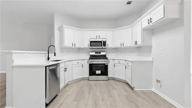 a kitchen with granite countertop a stove top oven sink and cabinets