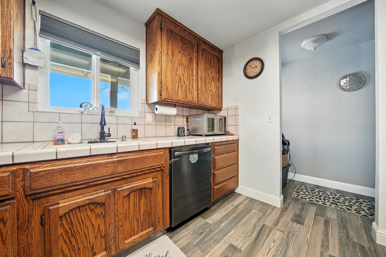 9680 Warren Road Valley Springs, CA 95252 - Photo 25 of 51 a kitchen with stainless steel appliances granite countertop a sink and cabinets with wooden floor