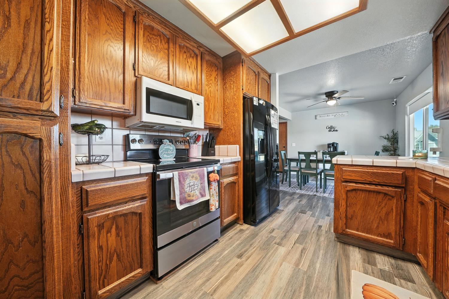 9680 Warren Road Valley Springs, CA 95252 - Photo 27 of 51 a kitchen with stainless steel appliances granite countertop wooden cabinets a sink dishwasher a stove and a refrigerator with wooden floor