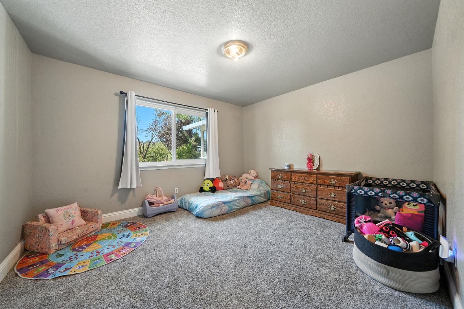 9680 Warren Road Valley Springs, CA 95252 - Photo 37 of 51 a bedroom with furniture and a toys
