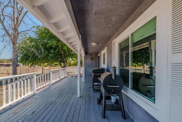 a view of a porch with furniture and wooden floor