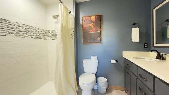 a bathroom with a granite countertop toilet sink and mirror