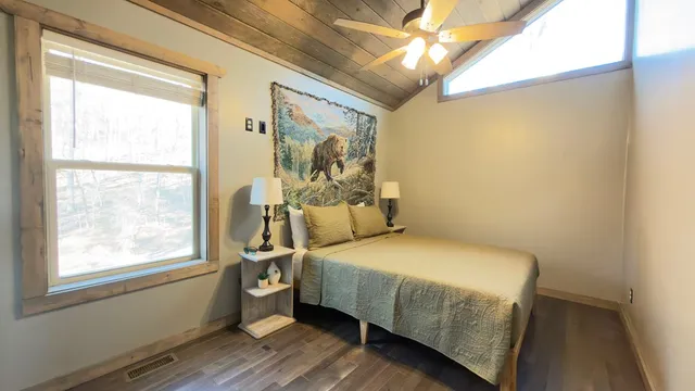 a bedroom with a bed and wooden floor