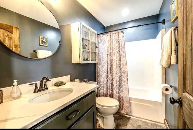 a bathroom with a sink toilet a mirror and shower