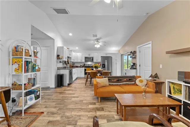 a living room with furniture kitchen view and a large window