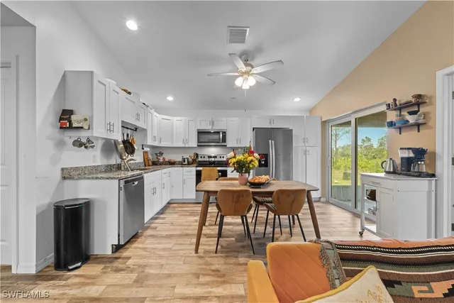 a view of a dining room with furniture a kitchen and chandelier