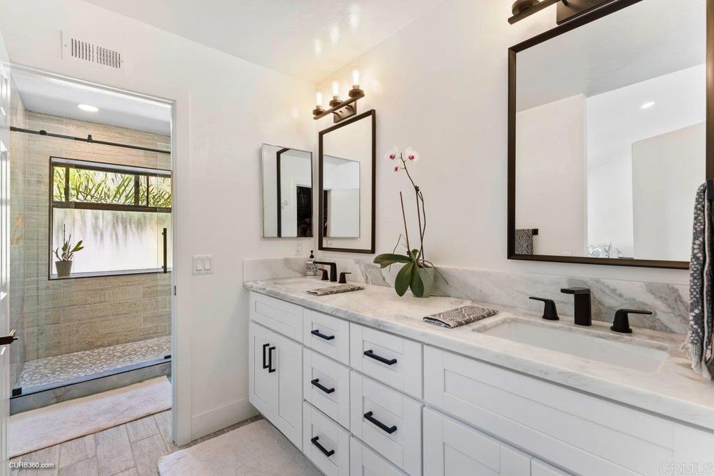 1618 Buttercup Road Encinitas, CA 92024 - Photo 23 of 33 a bathroom with a double vanity sink and a mirror