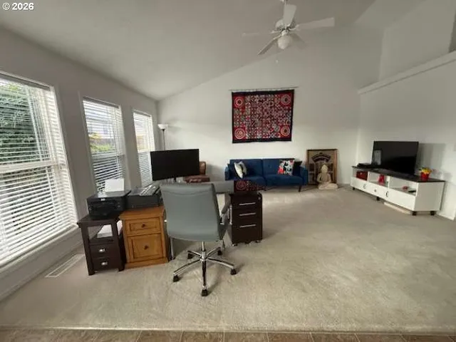 a view of a livingroom with workspace and a window
