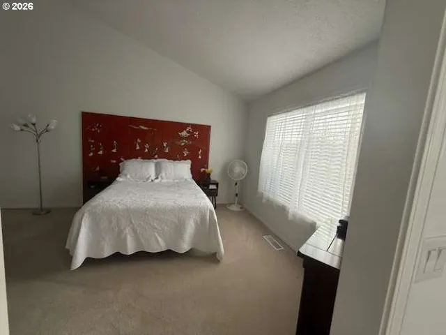 a bed sitting in a bedroom next to a window