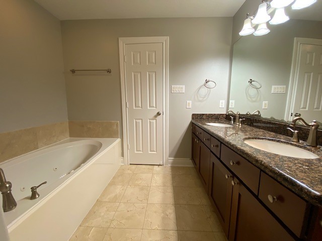 3415 Clearview Circle Houston, TX 77025 - Photo 14 of 16 a bathroom with a granite countertop sink a bathtub a mirror a vanity and bathtub