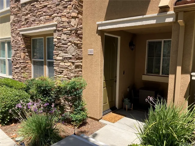 a view of a door of the house with a yard