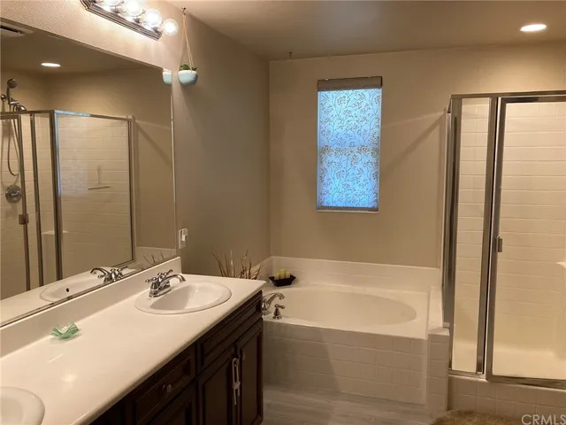 a bathroom with a tub a sink and mirror