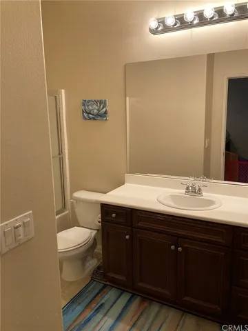 a bathroom with a toilet a sink and mirror