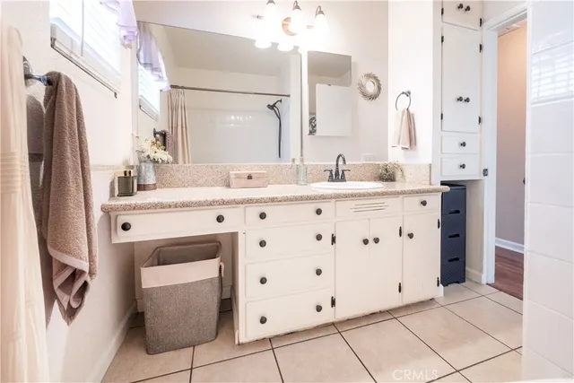 a bathroom with a double vanity sink mirror and shower