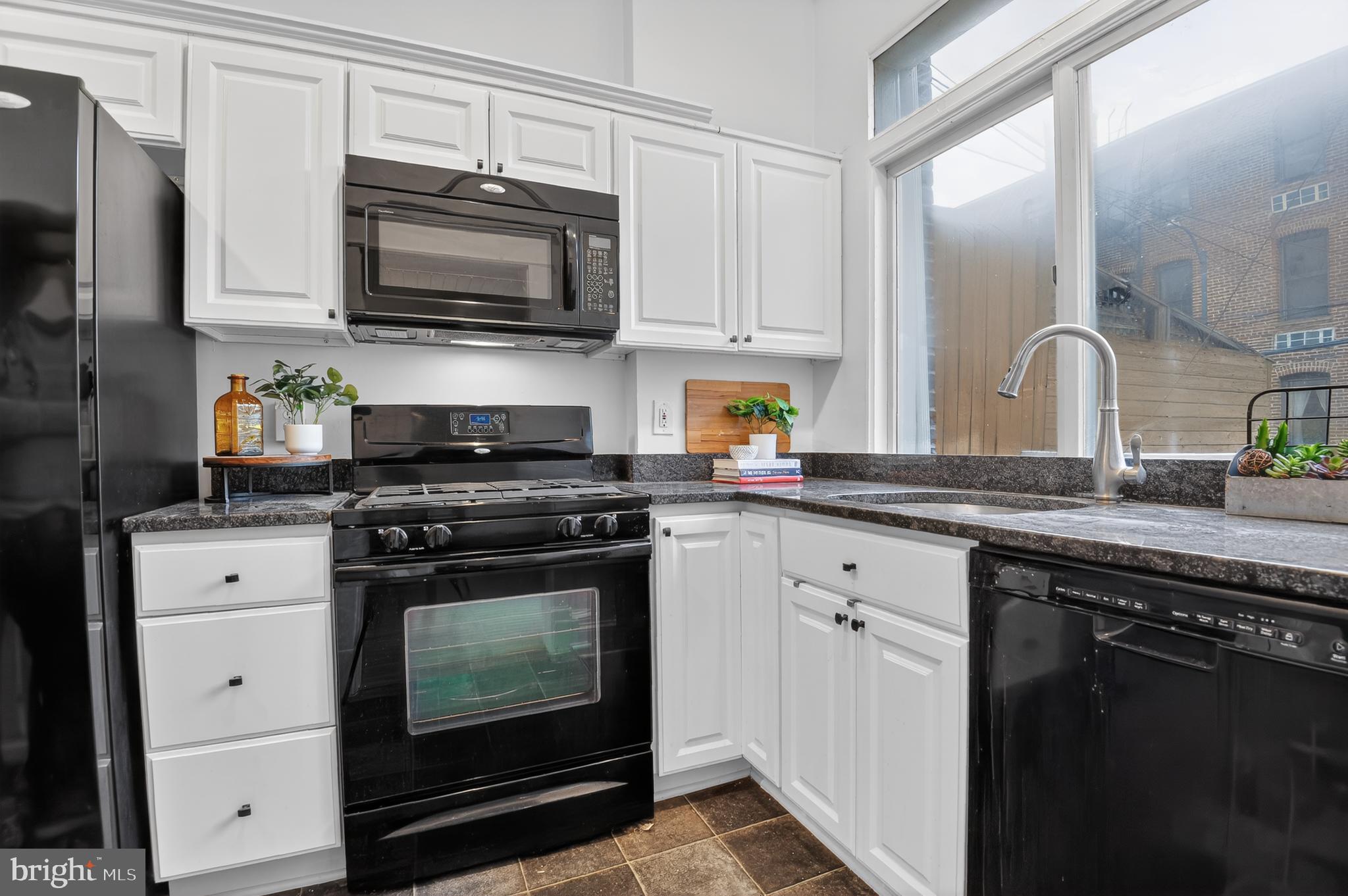 1752 Willard Street Northwest Washington, DC 20009 - Photo 13 of 26 a kitchen with stainless steel appliances granite countertop a stove microwave and sink