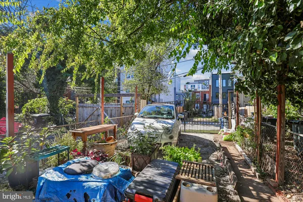 a view of a patio with table and chairs potted plants and large tree