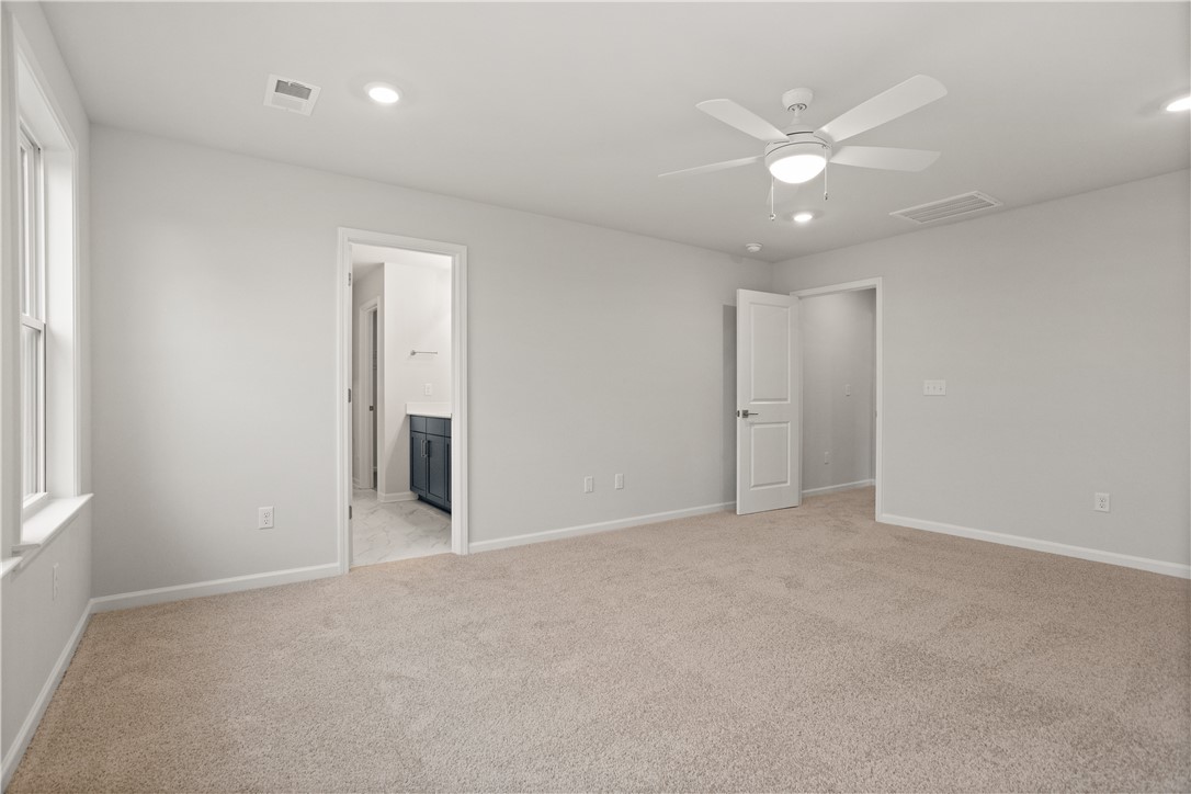 629 Sweetspire Trail, Unit 149 Seneca, SC 29678 - Photo 23 of 30 A spacious bedroom with plush carpeting, offering direct access to a private bathroom, illuminated by recessed lighting.