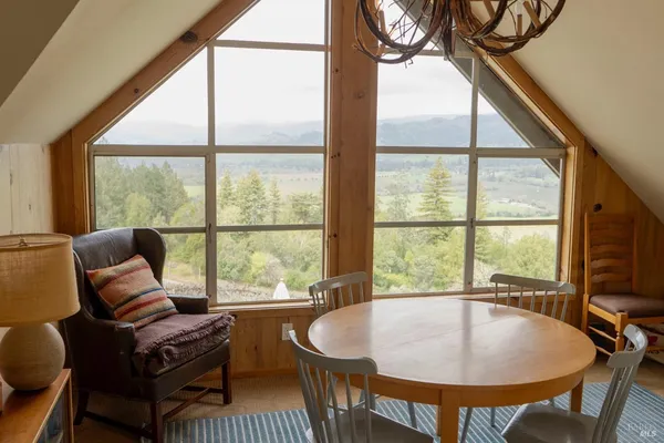 a living room with furniture a large window and a table