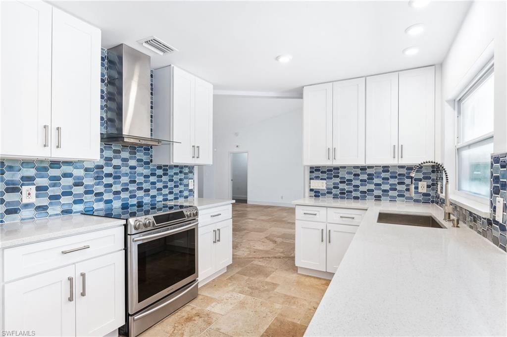 2360 Outrigger Lane Naples, FL 34104 - Photo 18 of 50 a kitchen with white cabinets and appliances