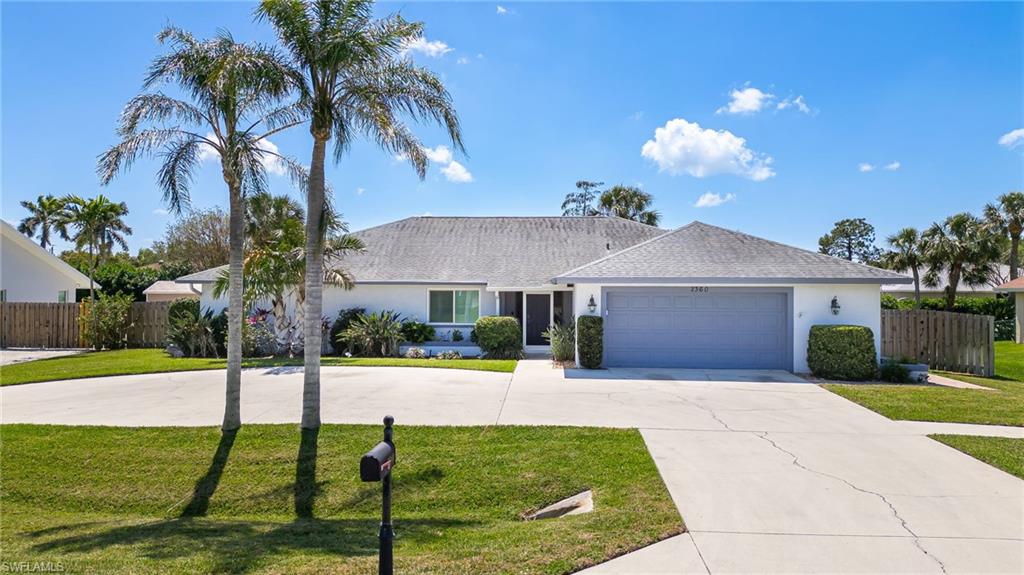 2360 Outrigger Lane Naples, FL 34104 - Photo 2 of 50 a front view of a house with garden