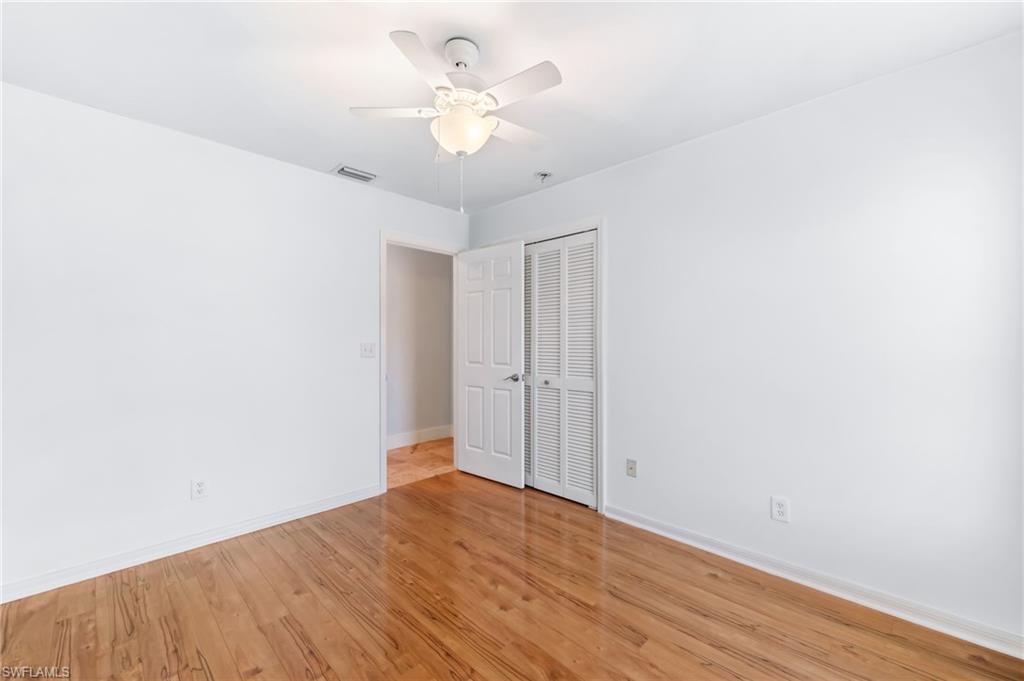 2360 Outrigger Lane Naples, FL 34104 - Photo 34 of 50 an empty room with wooden floor and ceiling fan