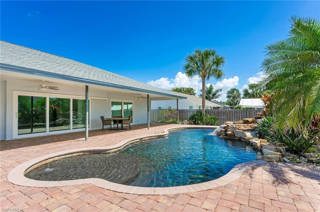 2360 Outrigger Lane Naples, FL 34104 - Photo 42 of 50 a view of pool with lawn chairs plants and large tree