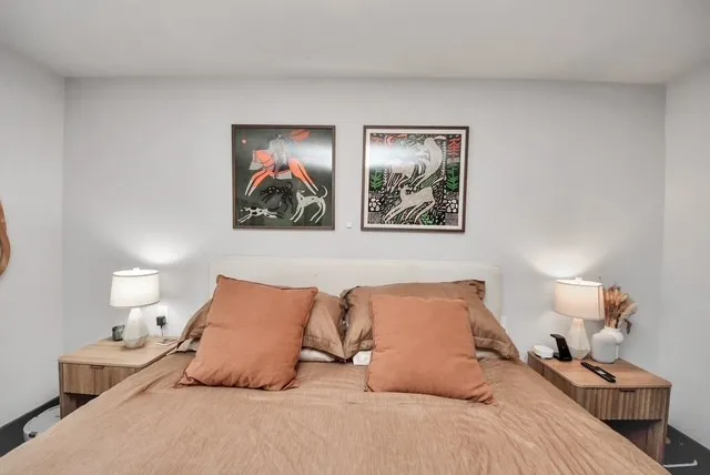 a bedroom with bed and painting on the wall