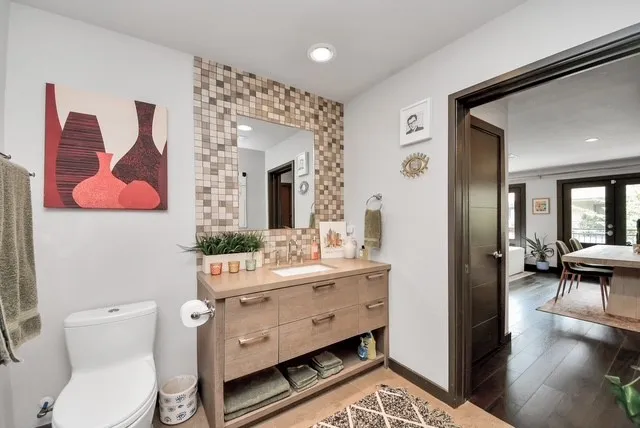 a bathroom with a toilet sink and mirror