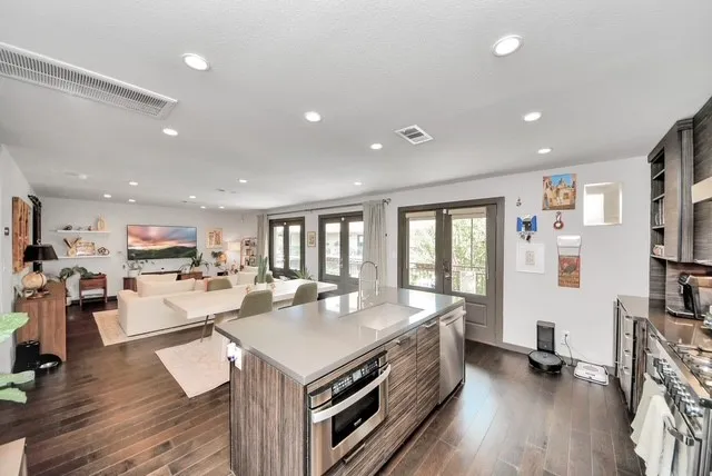 a large kitchen with kitchen island a large counter top space a sink a stove and a refrigerator