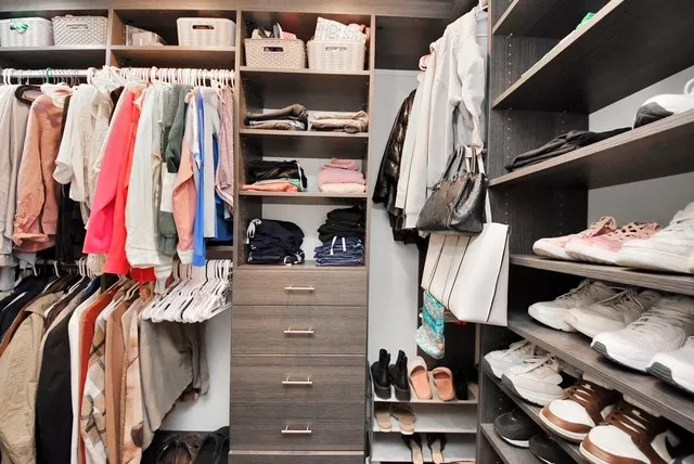 a view of walk in closet with clothes and shoes