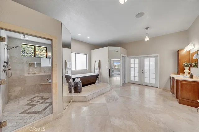a bathroom with a granite countertop double vanity sink and mirror