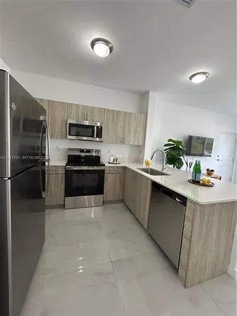 a kitchen with granite countertop a refrigerator and a stove top oven