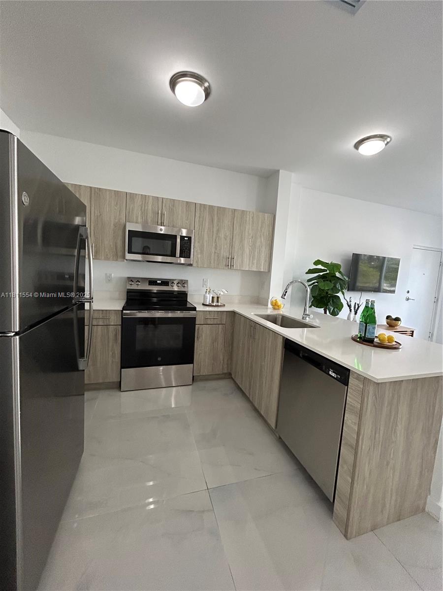 1010 Southwest 69th Avenue, Unit 212 Miami, FL 33144 - Photo 11 of 30 a kitchen with granite countertop a refrigerator and a stove top oven