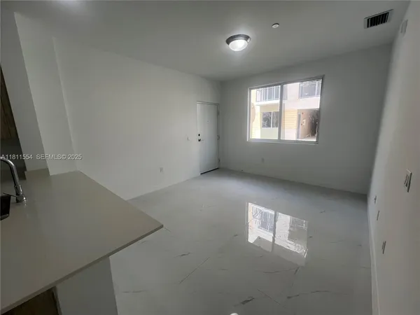 a view of a kitchen with a sink and a refrigerator
