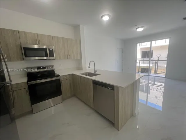 a kitchen with granite countertop a refrigerator and a stove top oven