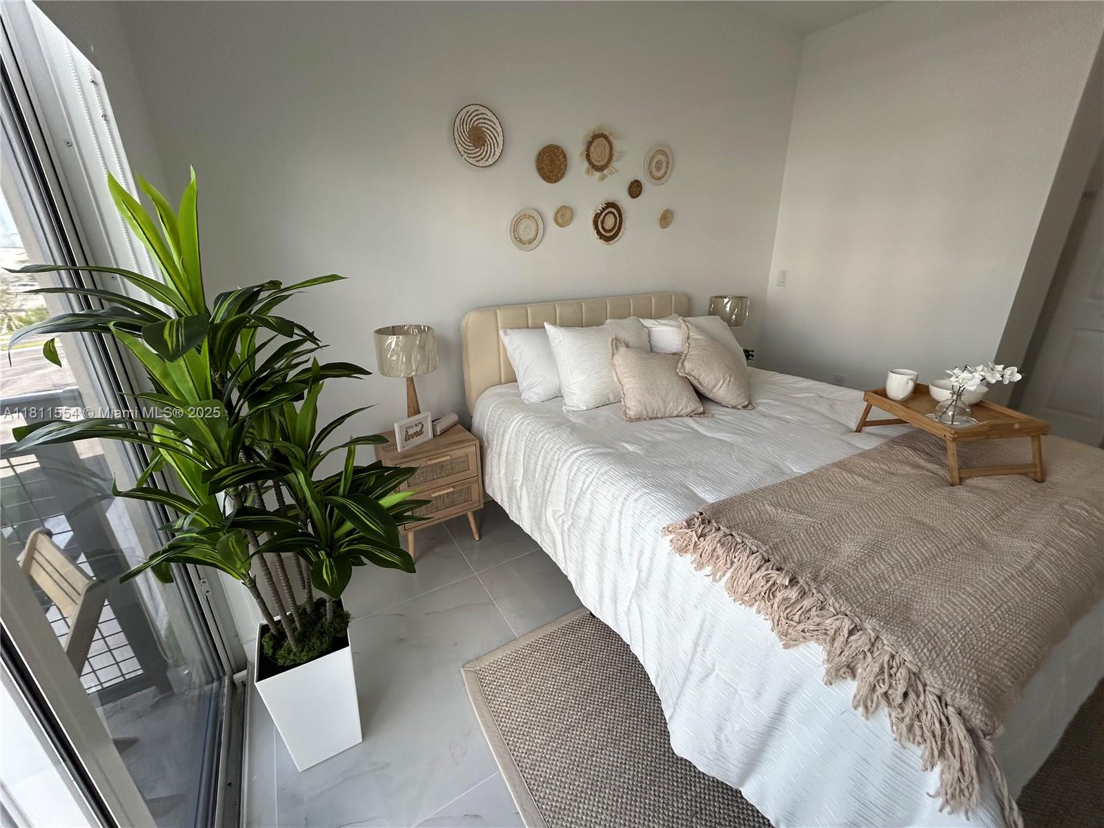 1010 Southwest 69th Avenue, Unit 212 Miami, FL 33144 - Photo 7 of 30 a bedroom with a large bed and a potted plant