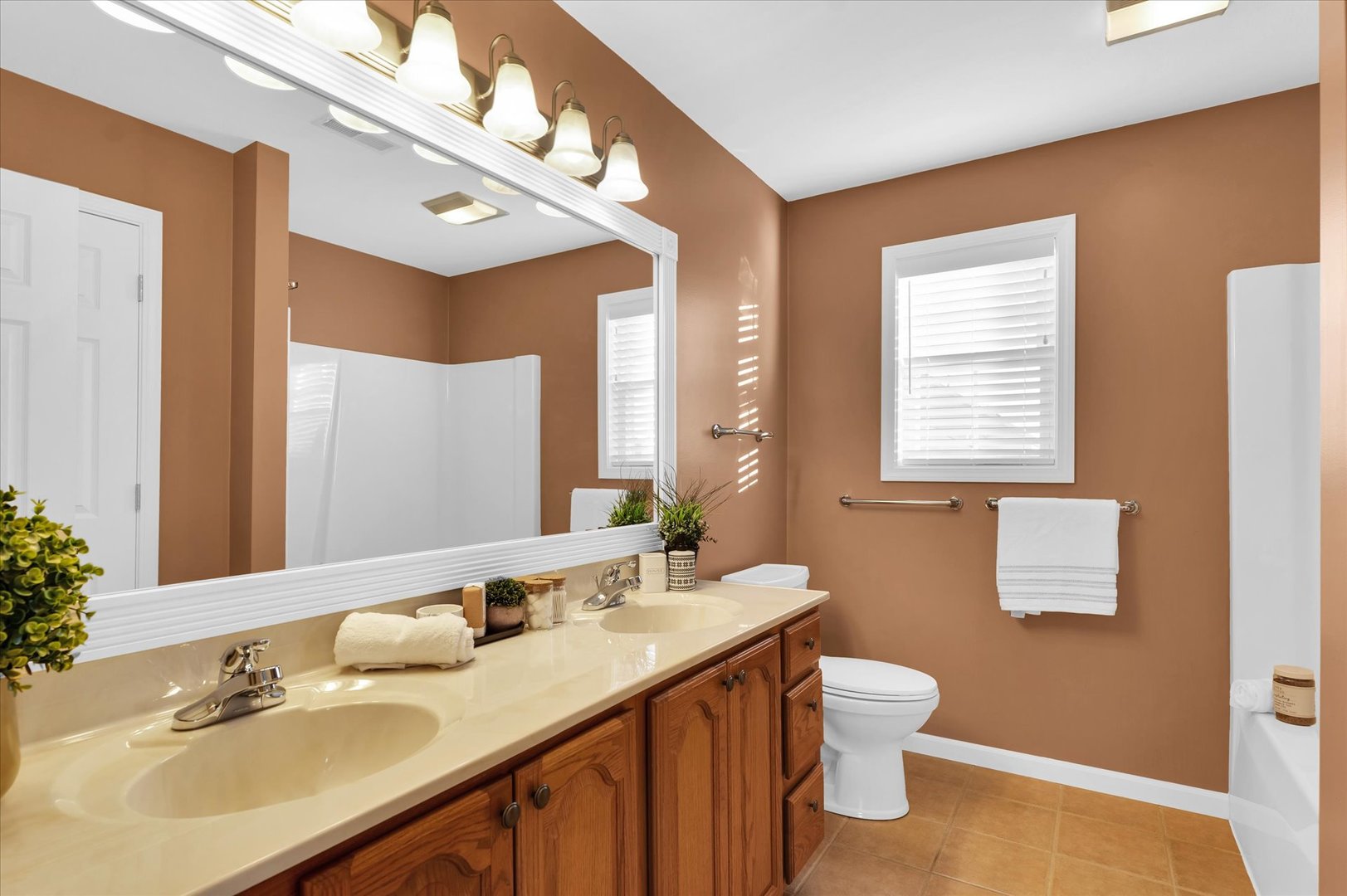 1330 West Ridge Lane Champaign, IL 61822 - Photo 27 of 39 a bathroom with a double vanity sink toilet and a mirror