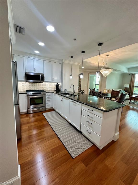 9115 Strada Place, Unit 5211 Naples, FL 34108 - Photo 2 of 31 a kitchen with stainless steel appliances kitchen island granite countertop a stove a sink a refrigerator and a microwave