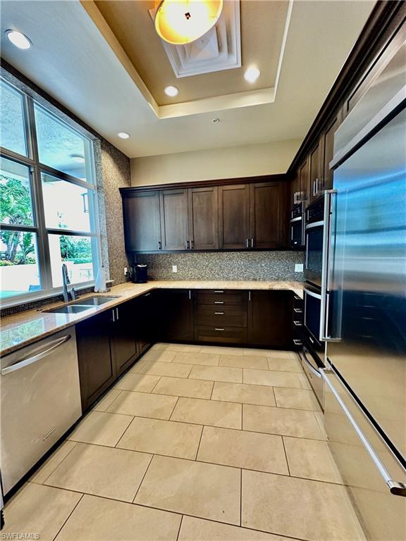 9115 Strada Place, Unit 5211 Naples, FL 34108 - Photo 23 of 31 a large kitchen with granite countertop a stove a sink and a microwave