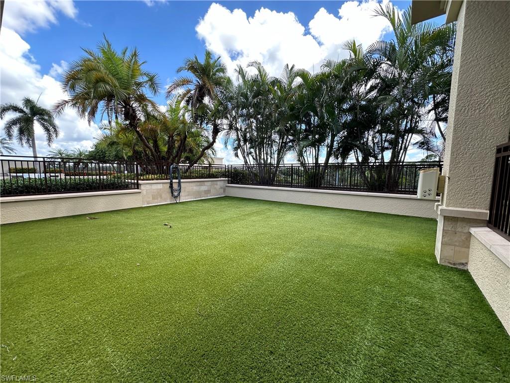 9115 Strada Place, Unit 5211 Naples, FL 34108 - Photo 30 of 31 a view of a swimming pool with a yard and palm trees