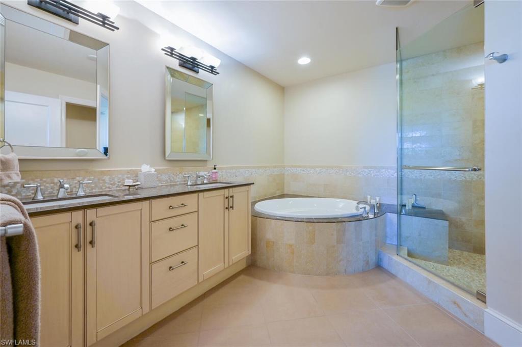 9115 Strada Place, Unit 5211 Naples, FL 34108 - Photo 9 of 31 a bathroom with a granite countertop sink a toilet and a mirror