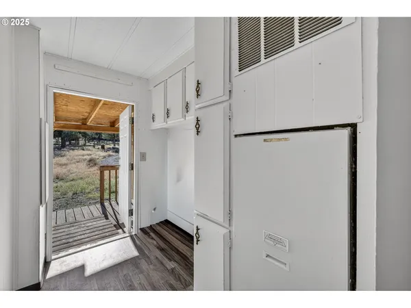 a view of a kitchen with wooden floor and a refrigerator