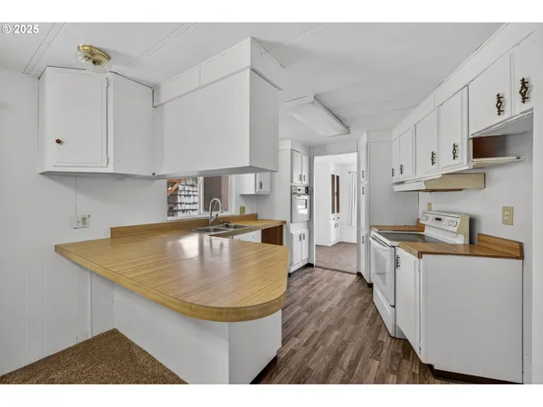 a kitchen with stainless steel appliances granite countertop a sink a stove counter space and cabinets