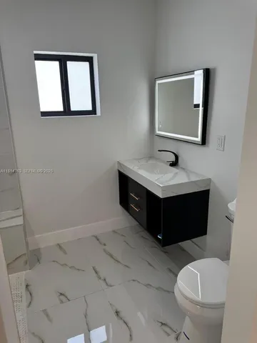 a bathroom with a toilet sink and mirror