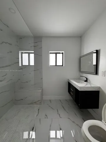 a view of bathroom with a toilet sink and mirror