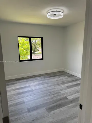 a view of a room with wooden floor and window