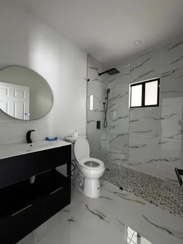 a bathroom with a toilet a sink and mirror