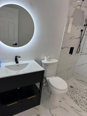 a bathroom with a sink toilet and mirror