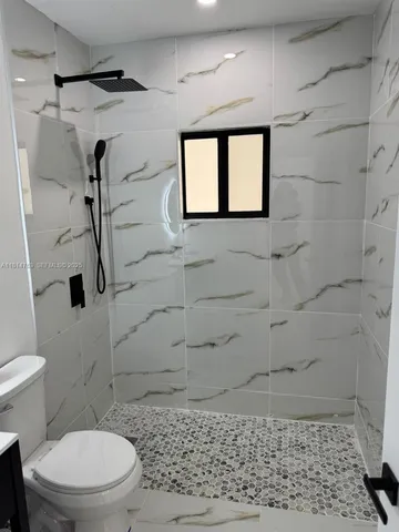 a bathroom with a toilet and a shower